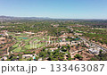Vale de Lobo, Algarve, aerial view inland valley course rolling hills and scattered villas, intricate fairways weaving through cork oaks, distant mountains, bright clear sky, calm rural 133463087