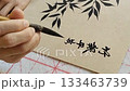 A person practicing traditional Chinese calligraphy mean "Bamboo represents peace, tranquility, and serenity." 133463739