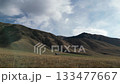 Scenic landscape with rolling hills and distant structure, camera pans right 133477667