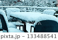 Snow covered outdoor terrace furniture near Grenoble after early winter snowfall, France 133488541