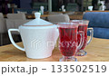 Teapot red drinks cup of tea on a table. Hot drink.Cup of tea with lemon and mint leaves  133502519