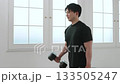 A man in his 20s doing muscle training with dumbbells A man in his 20s doing muscle training with dumbbells 133505247