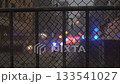 A seamless loop video depicting the urban atmosphere of an emergency vehicle's light reflected on a metal fence 133541027