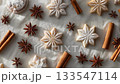 A minimalist flat lay of Christmas cookies coated with powdered sugar, cinnamon stick and star anise on parchment paper 133547114