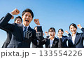 A large group of business people making a fist pump under the blue sky A large group of business people making a fist pump under the blue sky 133554226