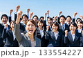 A large group of business people making a fist pump under the blue sky A large group of business people making a fist pump under the blue sky 133554227