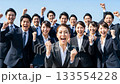 A large group of business people making a fist pump under the blue sky A large group of business people making a fist pump under the blue sky 133554228