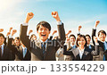 A large group of business people making a fist pump under the blue sky A large group of business people making a fist pump under the blue sky 133554229