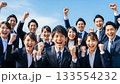 A large group of business people making a fist pump under the blue sky A large group of business people making a fist pump under the blue sky 133554232