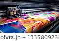 Closeup of a large format inkjet printer working on a roll of vinyl, printing a colorful floral pattern in a typography. Industrial production of fabrics and advertising banners in a factory 133580923