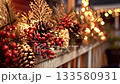Festive holiday garland featuring golden ornaments, pine cones, red berries, and fir branches, beautifully adorning a wooden railing with twinkling bokeh lights creating a warm, inviting atmosphere 133580931