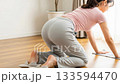 Rear view of a young woman carefully mopping the living room floor 133594470