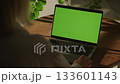 Person using laptop with green screen indoors 133601143