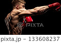 Muscular male boxer attacking with a powerful punch during an intense fight, demonstrating strength, discipline, and competitive spirit on a dark studio background 133608237