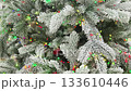 Frosty Christmas tree adorned with colorful lights in a festive winter setting 133610446