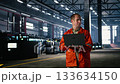 Professional specialist operating equipment in industry plant, supporting colleague personnel and maintaining structured manufacturing process around steel machinery within factory. Camera A. Professional specialist operating equipment in industry plant, supporting colleague personnel and maintaining structured manufacturing process around steel machinery within factory. Camera A. 133634150