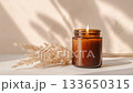 Elegant creative lit candle video mockup, amber jar soy wax candle in beige boho styled interior 133650315