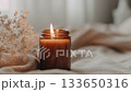 Elegant creative lit candle video mockup, amber jar soy wax candle in beige boho styled interior 133650316