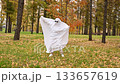 Woman in a ghost costume in the autumn forest. Halloween costume. 133657619