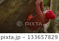 man rock climber showing high climbing skills, strength and power during climbs bouldering on edge of overhanging cliff. healthy lifestyle, active leisure. rock climbing outdoor in autumn forest. 133657829