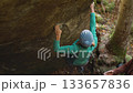 slow motion woman climber climbs crag bouldering reaching holds and making hard movements showing strength and power. healthy sport lifestyle, active leisure. rock climbing outdoors in autumn forest. 133657836