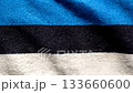 Aerial top down view of the Estonian flag waving in the wind, black blue white tricolor, smooth fabric movement, patriotic minimalistic background for events and presentations 133660600