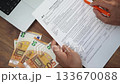 Office worker pays careful attention to examining W-4 form using pen to point out specific lines, man ensures all details meet tax compliance standards slow motion 133670088