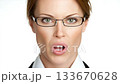 Confident woman with glasses making a playful face in a professional setting 133670628