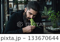 Man interacts with green parrot in a cozy indoor setting during the day 133670644