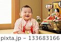 [Girls' Festival] A baby in a pink kimono stands with a big smile next to the Hina dolls 133683166