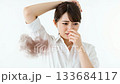 A Japanese woman grimaces at the foul odor that has permeated her shirt A Japanese woman grimaces at the foul odor that has permeated her shirt 133684117