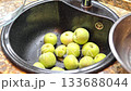 Washing apples in kitchen sink 133688044
