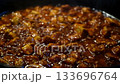 Sizzling beef cooking in pan with rich aromatic sauce and simmering steam 133696764