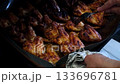 Succulent barbecue chicken wings being juiced and seasoned in closeup cooking sequence 133696781