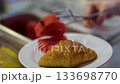 Croissant watermelon fork table with breakfast served, a knife, spoon and fork of bronze color with elegant black stand out 133698770