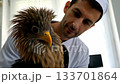 Male vet holds eagle in treatment room. Ai generated 133701864