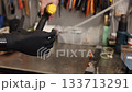 electric drill, workshop repair, prosthetic assistance. Close-up shot shows person holding yellow electric drill with both hands, where one hand is prosthetic. 133713291