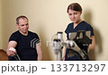 Physiotherapy robots, Recovery robots, Disabled person. During rehab session, man performs arm exercises with help of therapist skilled in robotic technology. 133713297