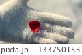 Small Red Heart Lies on a White Glove in Snowy Winter for Valentine's Day 133750153