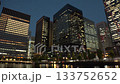 Tokyo, Japan: Skyscrapers around Tokyo Station. Night view of the densely packed business district with office buildings (time-lapse photography) 133752652