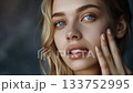 A beautiful blonde woman with blue eyes touching her face_4 133752995