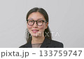 Portrait of confident young woman in glasses on gray background.  133759747