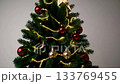 Illuminated christmas tree with golden lights and ornaments in cozy living room setting 133769455