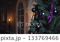 Elegant christmas tree with black ornaments illuminated by warm candlelight in cozy interior 133769466