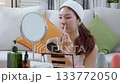 Beauty happy young asian woman applying makeup with brush looking mirror. 133772050