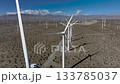 Descending Drone over wind turbines in the San Gorgonio Pass near Palm Springs, California. Expanding aerial view of clean energy infrastructure across desert terrain. 133785037