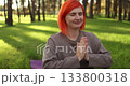 crimsonhaired woman peacefully meditates on purple mat at dawn amidst pine trees 133800318