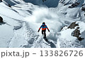 Dynamic follow shot captures snowboarder in bright orange gear charging down remote backcountry slope, with fine powder blast enveloping board 133826726