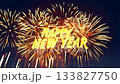 Golden Happy New Year text shimmering against a black night sky with sparkling golden fireworks. Bright celebratory animation 133827750