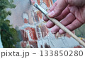 Artist painting a cityscape on canvas with brush 133850280